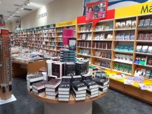Librería con libros destacados en mesas y estantes.
